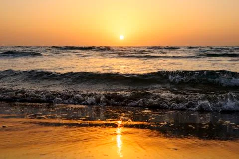 A bright sunset in a cloudless sky on the Mediterranean Sea with waves in Isr Foto stock