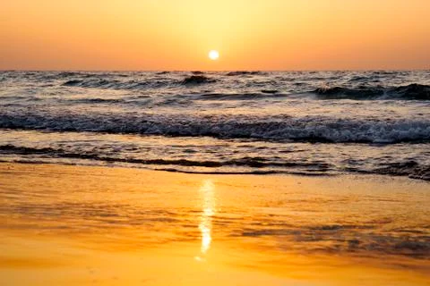 A bright sunset in a cloudless sky on the Mediterranean Sea with waves in Isr Stock Photos