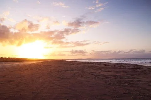 Bright sunset on the coast by the ocean Stock Photos