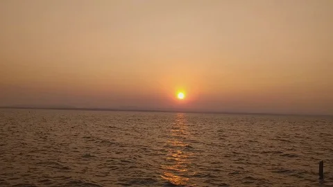 Bright sunset with large yellow sun under the sea surface Stock Footage 128561870