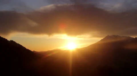 Bright Sunset in the Mountains, Dark Clouds, the Lights of a Sun Stock Footage 63573360