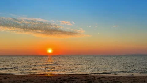 Bright sunset over calm ocean water horizon with sky and sun light clouds. Stock Footage 344873619