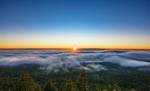 Bright sunset over the clouds and blue sky 스톡 사진