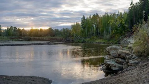 Bright sunset with reflection in the water of a small river Kempendyay in Yak Stock Photos