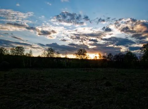 Bright sunset in spring through the clouds Stock Photos