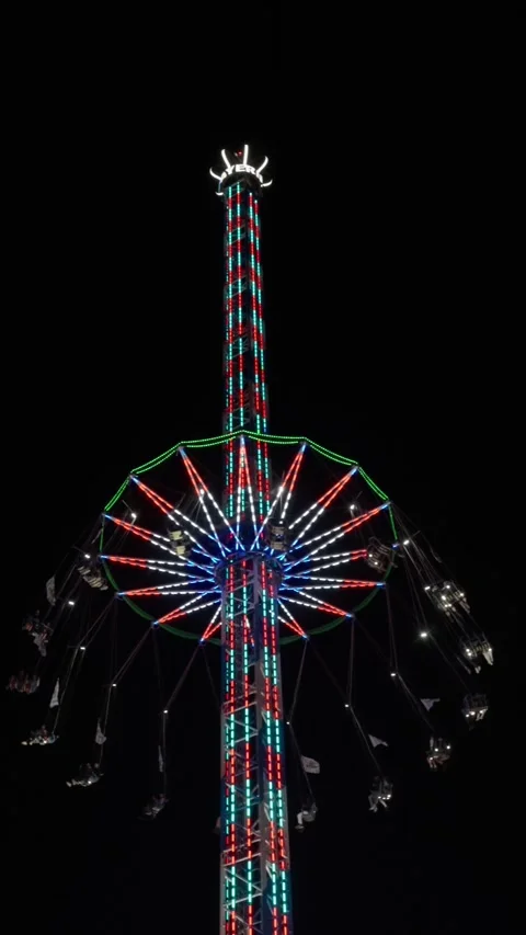 Bright swinging tower, luminous tower with spinning gondolas, tower of light Stock Footage 319658913