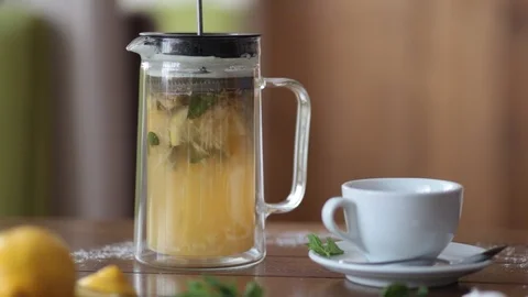 Bright tea with lemon and mint in a teapot press, pour into a Cup. Morning tea. Video stock 111854747