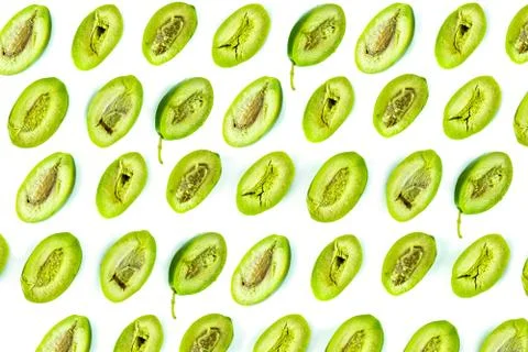 Bright top view pattern of fresh green olives cut in half on white background Stock Photos