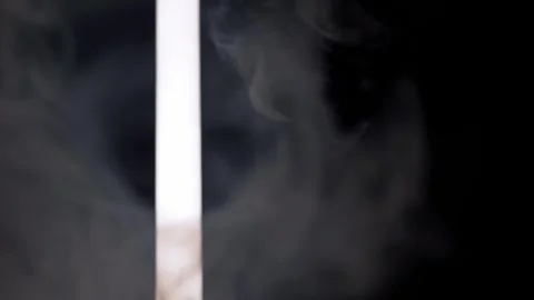 Bright Vertical Slit of Light Shining Through Billowing Smoke in Darkness Video stock 338995948