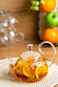 Bright vitamin tea with fruit in a glass teapot on the kitchen table Stock Photos