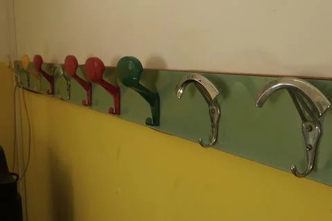 A bright wall hanger with multi-colored metal and plastic hooks. 스톡 사진