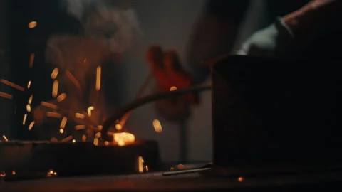 Bright welding arc creating sparks as metal bends glowing red Stock Footage 331900209