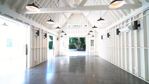 Bright white barn event space with pendant lights and open doors Stock Footage 345685415