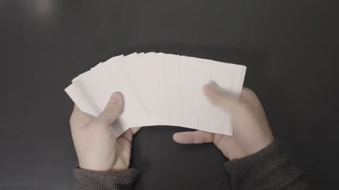 Bright White Cards Displayed in Hands then Straightened Stock Footage 100556789