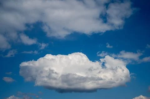 Bright white cloud floating in deep blue sky Stock Photos