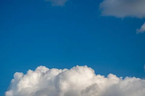 Bright white clouds float against blue, softedged cumulus with luminous dayli Stock Photos