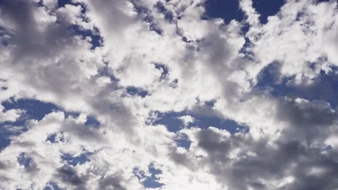 Bright white clouds moving across a deep blue sky Stock Footage 329757195