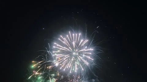 Bright white firework exploding against a dark night sky Stock Photos