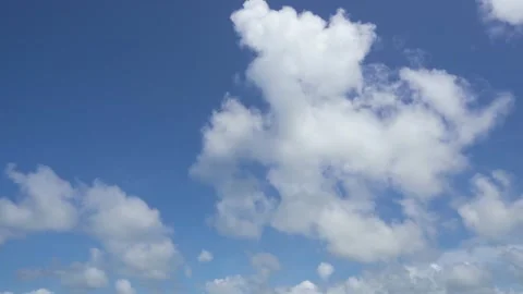 Bright white fluffy clouds fly in the blue sky on a sunny day. Stock Footage 157483757