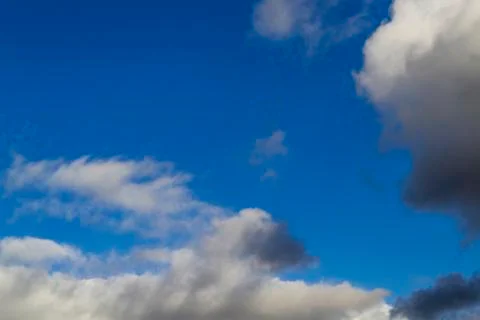 Bright white with grey clouds on blue sky. Beautiful background. Stock Photos