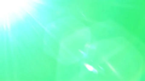 Bright White Light Lens Flare Overlaying a Vibrant Green Background in a Stock Footage 338368545
