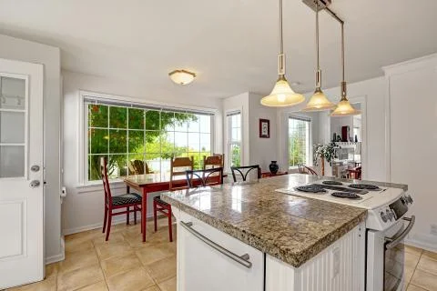 Bright white modern kitchen interior with island and dining area Stock Photos