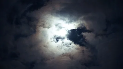 Bright white moon between gray volume cumulus clouds. Divination time. Stock Footage 108016164