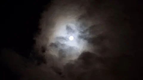 Bright white moon between volume fluffy clouds. Clouds run slow across the sky. Stock Footage 108013645
