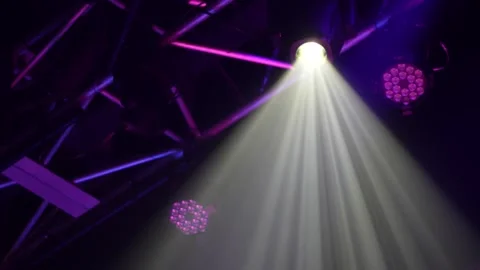 Bright white spotlight on purple illuminated metal stage truss Stock Footage 346332030