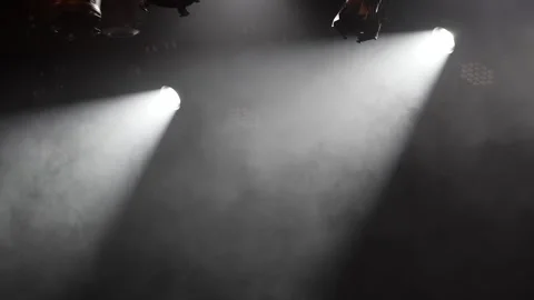 Bright white spotlights shining through smoke in dark stage Stock Footage 346303728