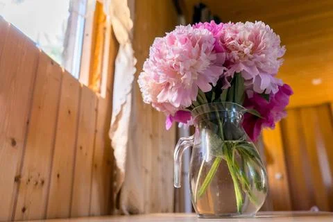 A bright window with flowers, a cup of coffee and a book on the windowsill Stock Photos