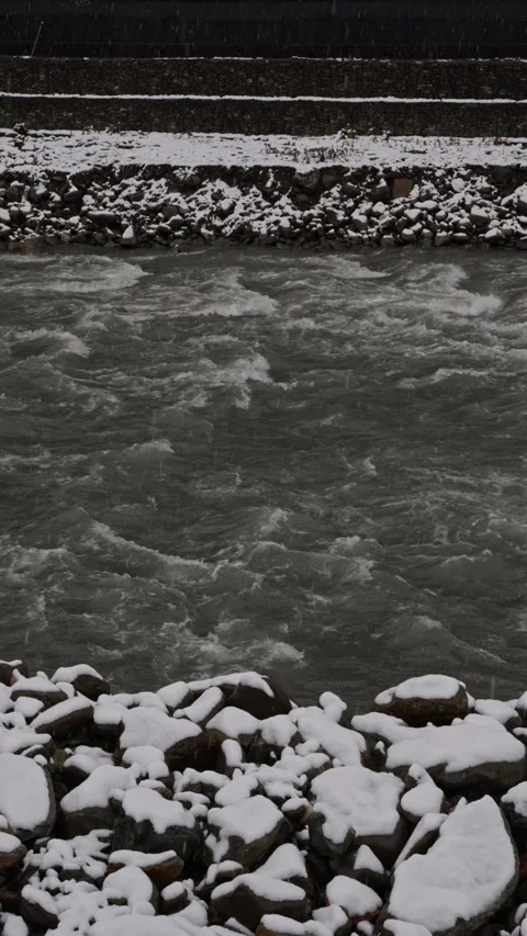 Bright winter scene showcasing turbulent river and snowcovered stones 스톡 동영상 333335324