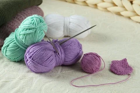 Bright yarns, pattern sample and knitting needles on soft blanket 스톡 사진