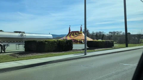 Bright yellow and red circus tent topped with American flags Stock Footage 333337917
