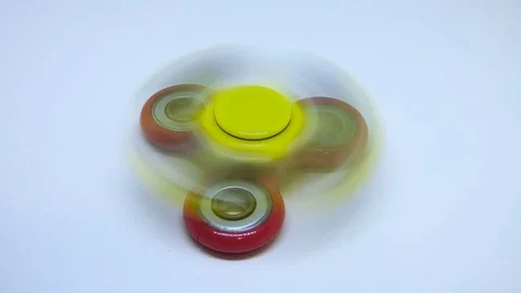 Bright yellow and red fidget finger spinners on white background Stock Footage 78240879