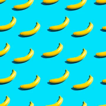 Bright yellow bananas on a blue background. Seamless pattern. Stock Photos