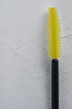 Bright yellow brush for combing eyebrows and eyelashes on light background... Foto stock