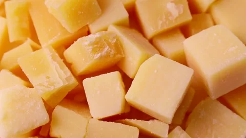 Bright yellow cheese pieces circle rotation close up top view Stock Footage 244302011