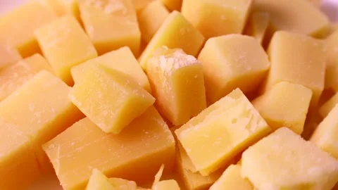Bright yellow cheese pieces circle rotation close up Stock Footage 245920002