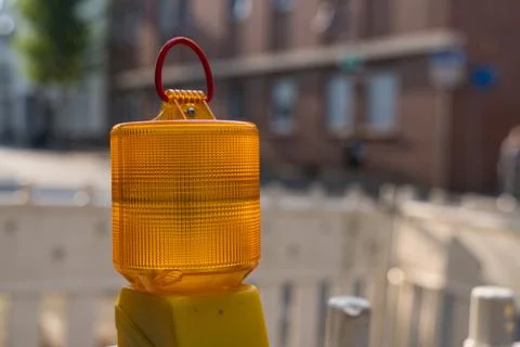 Bright yellow construction light marking a street work area Stock Photos
