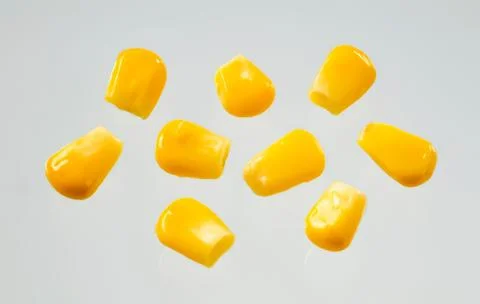 Bright yellow corn kernels on clean surface Stock Photos
