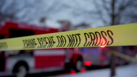 A bright yellow Crime Scene Do Not Cross tape stretched across the street at the 库存影片 310284052