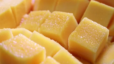 Bright yellow cube sliced fresh mango circle rotation close up Stock Footage 255973904
