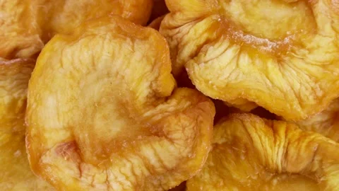 Bright yellow dried peach slices rotation close up top view Stock Footage 239656372