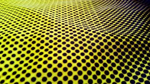 Bright yellow fabric featuring a repeating pattern of small dark dots Stock Photos