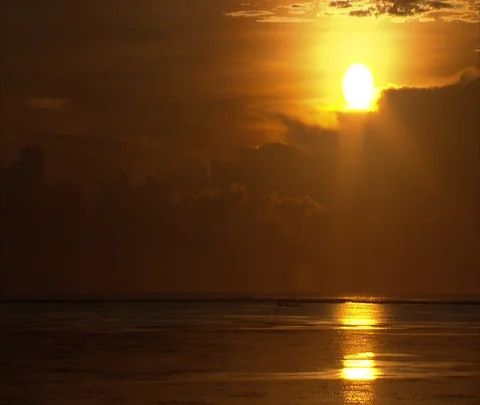 Bright yellow fireball sun rising, reflection in still orange water Stock Footage 86747740