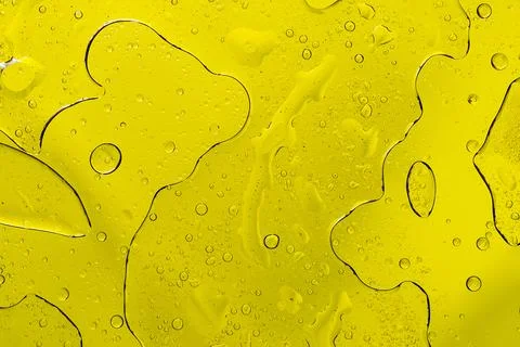 Bright yellow fluid texture with macro oil drops Fotos de archivo