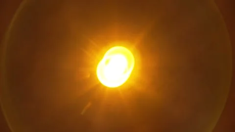 Bright yellow glowing light flare with circular lens flare on black background. Stock Footage 341227665