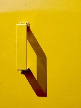 Bright Yellow Handle Casts Shadow on Industrial Metal Surface Stock Photos