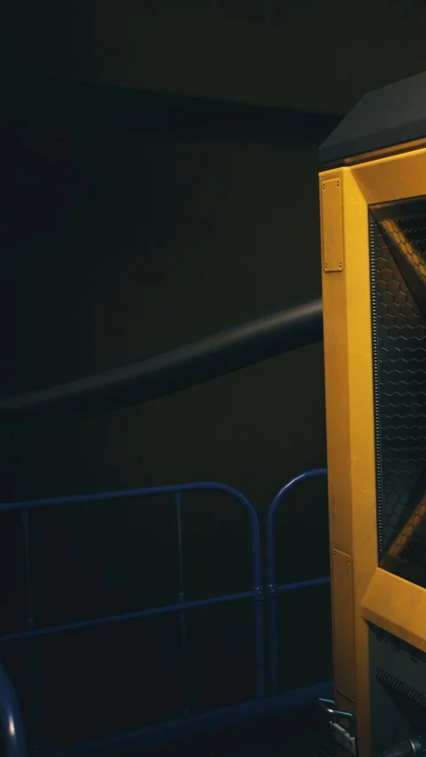 Bright yellow industrial machine standing in dark factory interior Video stock 331838452